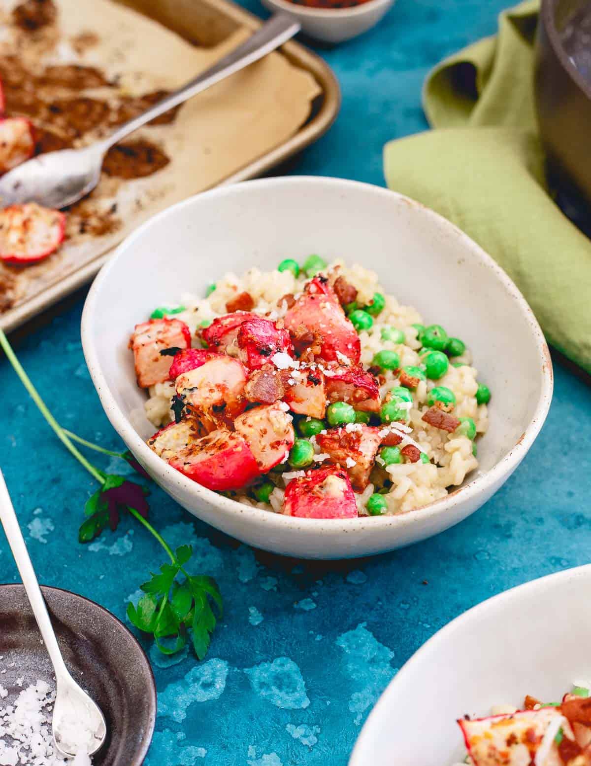 Creamy risotto meets bright lemon and mustard roasted radishes and fresh spring peas in this seasonal comfort food recipe.