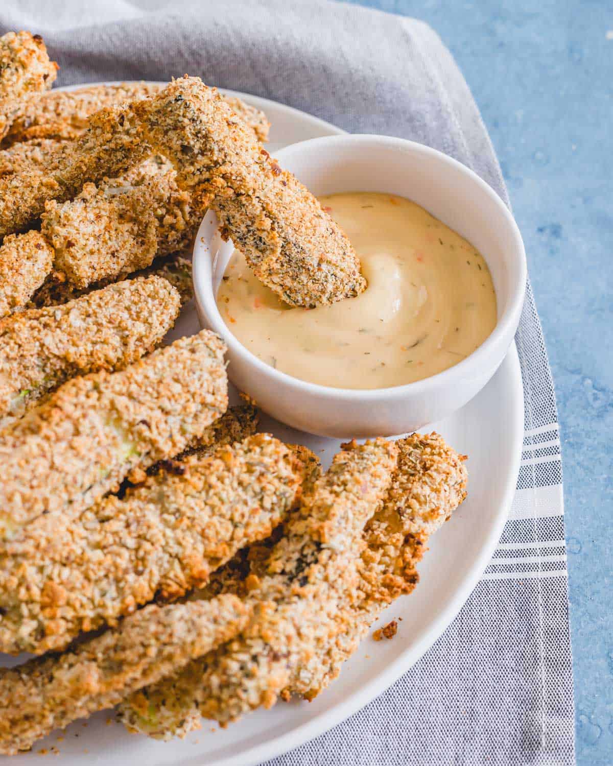 A baked zucchini fry in dipping sauce.