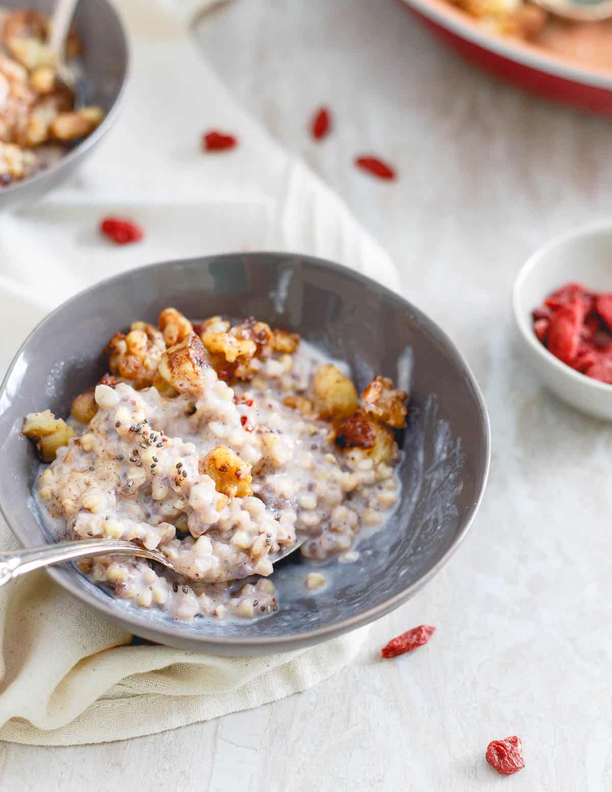 Step up your cereal game with this warm quinoa cereal bowl for breakfast. It's topped with caramelized bananas, walnuts, an almond butter drizzle, goji berries and some chia seeds!