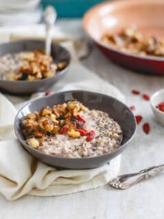 This warm quinoa cereal is topped with a caramelized banana and walnut compote, drizzled in almond butter and garnished with superfoods like goji berries and chia seeds.
