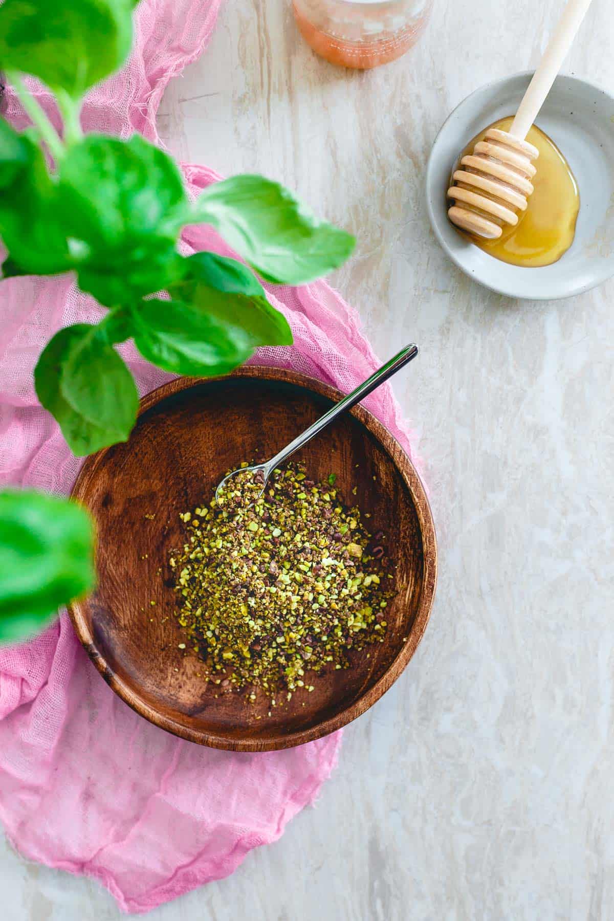 A pistachio cacao nib crumble takes this roasted strawberry basil milkshake over the top with a fun crunchy addition!