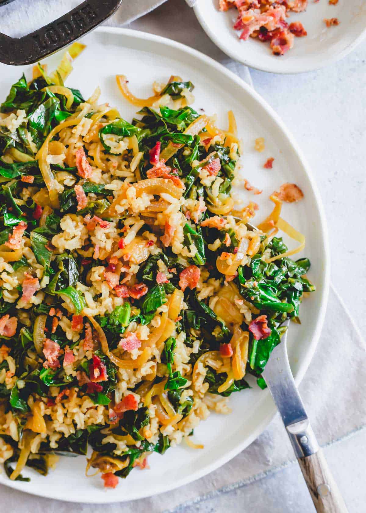 Sweet and spicy collard greens side dish recipe on a white plate.