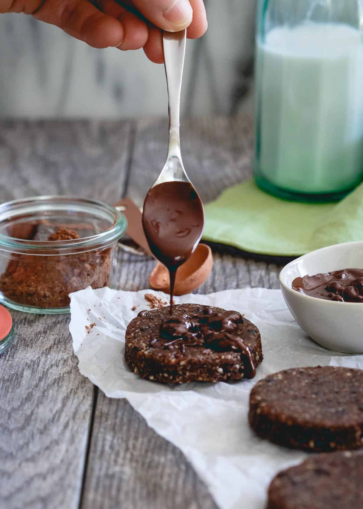 Raw brownie bites made with nuts, dried fruit and maple syrup are topped with a mint chocolate drizzle perfect for a healthy St. Patty's Day treat!