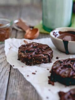 Raw brownie bites are a healthy way to satisfy a chocolate craving. Made with nuts, dried fruit and a chocolate drizzle, they're paleo, gluten-free and vegan dessert you can feel good about eating.