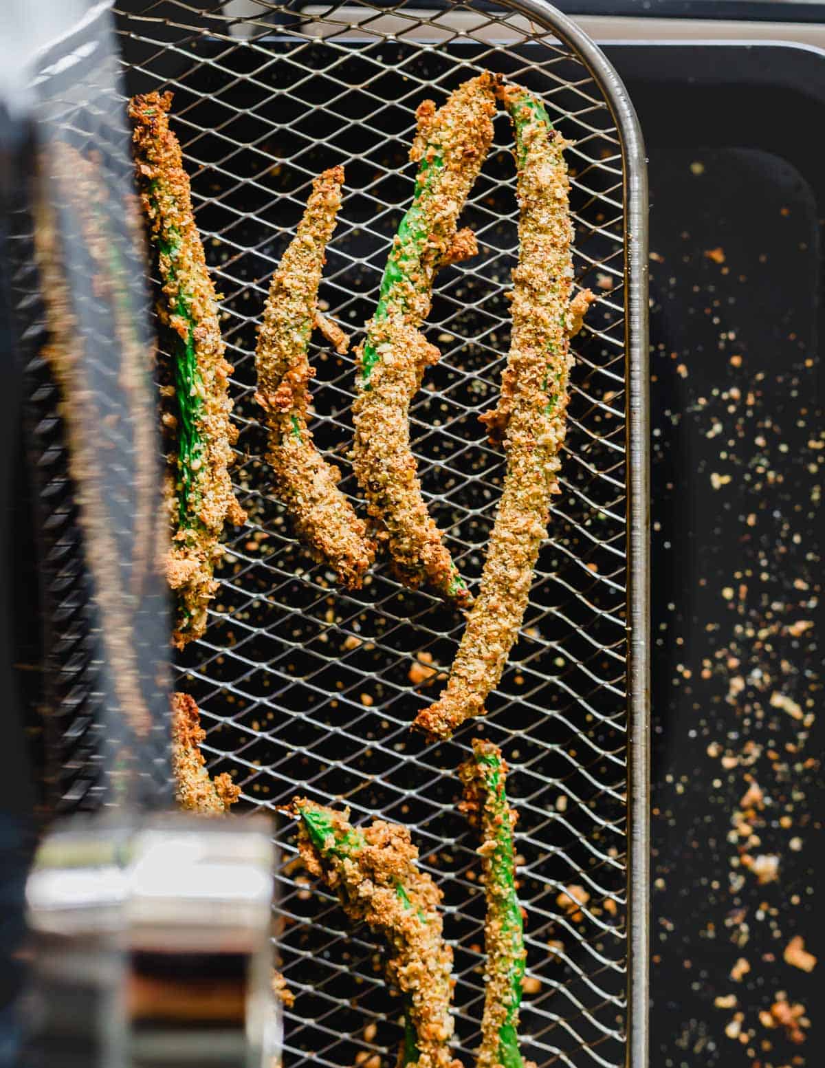 Air fried green beans coated with breadcrumbs on a tray in a Pampered Chef air fryer oven.