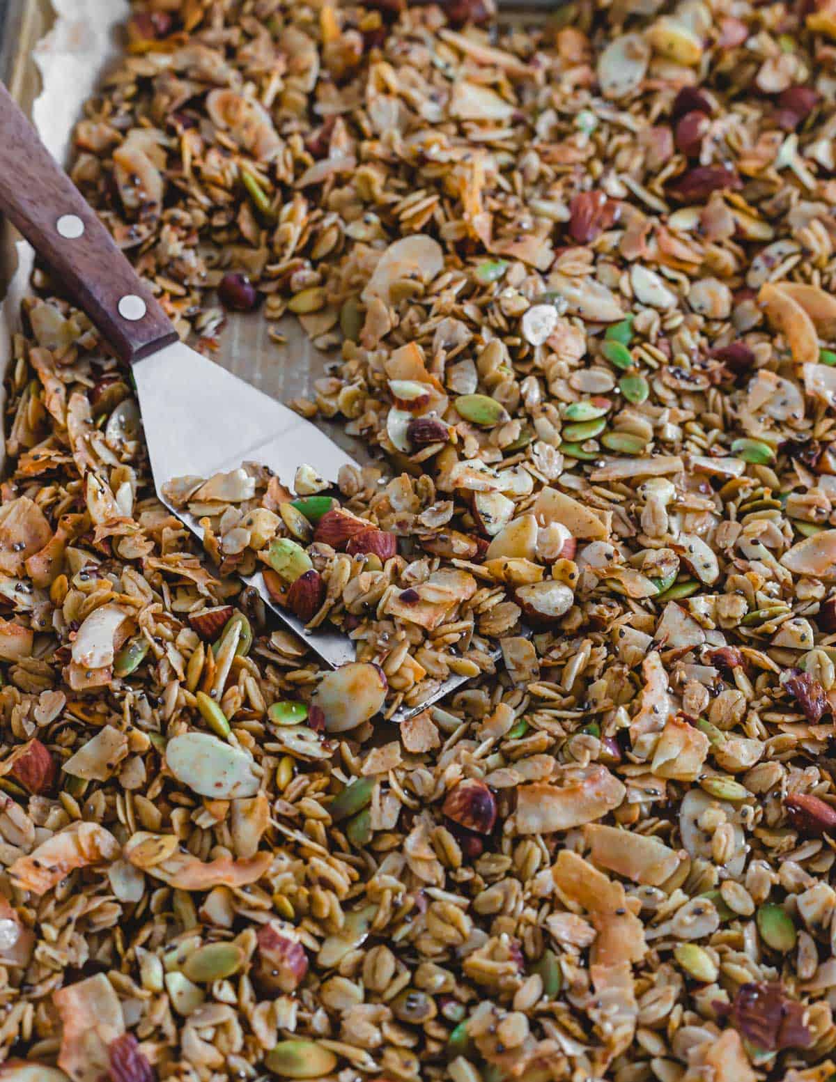 Baked coconut almond granola on a spatula.