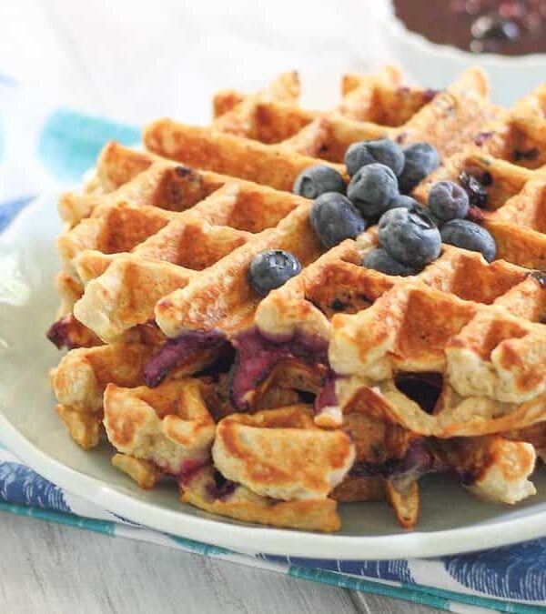 Oat waffles with fresh blueberries on a plate.