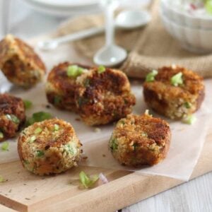 Crispy salmon bites on cutting board with dipping sauce.