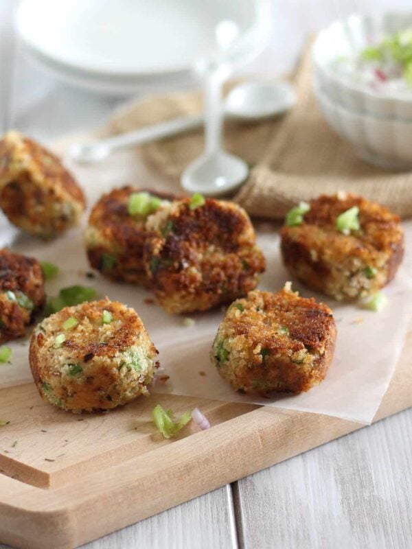 Crispy salmon bites on cutting board with dipping sauce.