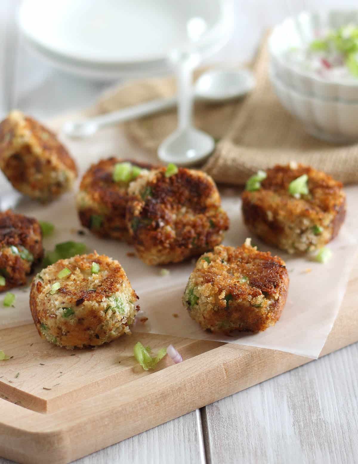 Crispy salmon bites on cutting board with dipping sauce.