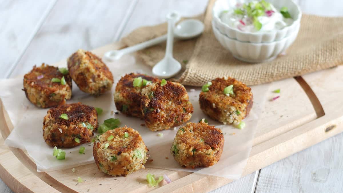 Pan-fried salmon bites on parchment paper and cutting board.