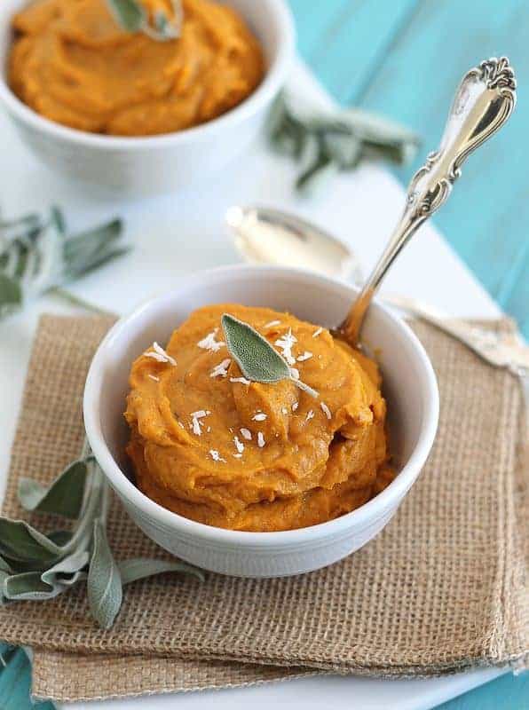 Coconut garlic butternut squash puree in a white bowl topped with shredded coconut. Coconut garlic butternut squash puree in a white bowl topped with shredded coconut.