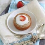 Individual vanilla cakes with strawberries and cream.