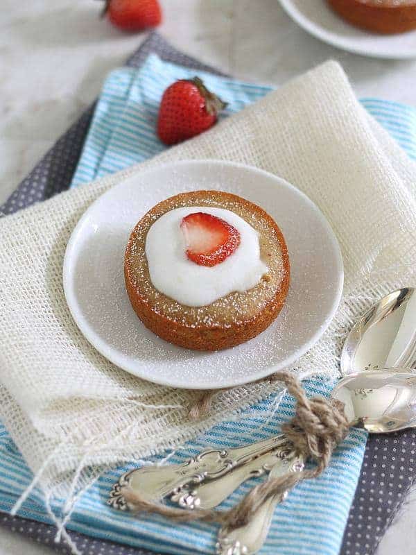 Individual vanilla cakes with strawberries and cream.