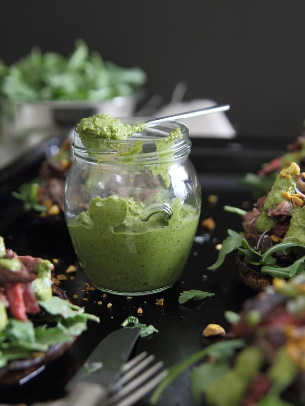 These balsamic steak stuffed portobellos are topped with a bright pistachio pesto.