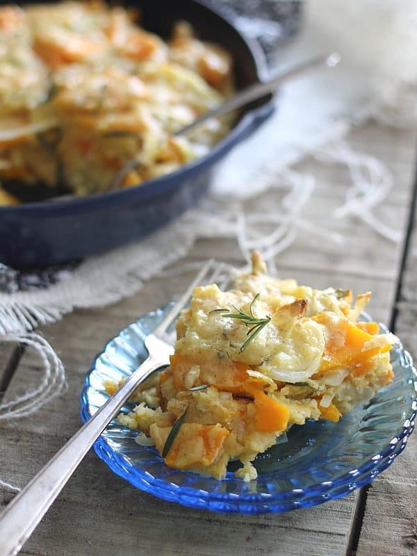 Savory squash pie on a small blue glass plate with a fork.