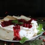 Pomegranate pavlova on a baking rack.
