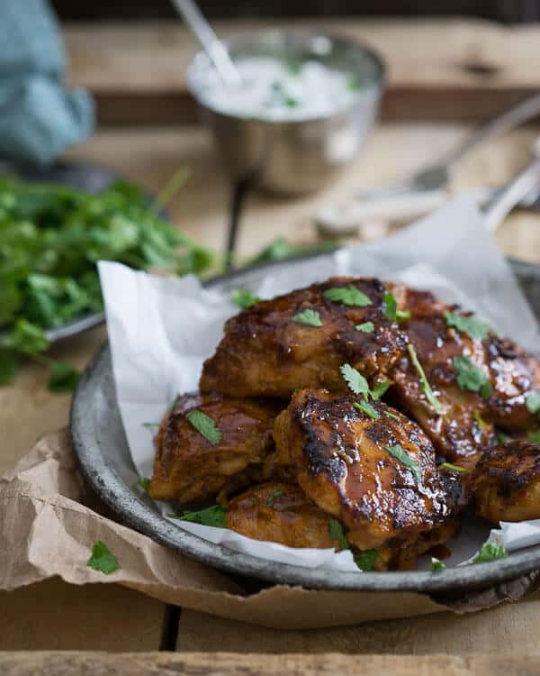 This sweet and spicy Indian chicken is marinated in yogurt and spices and finished with a sweet and sticky maple syrup glaze. It's outrageously delicious and will easily become your go-to chicken dinner.