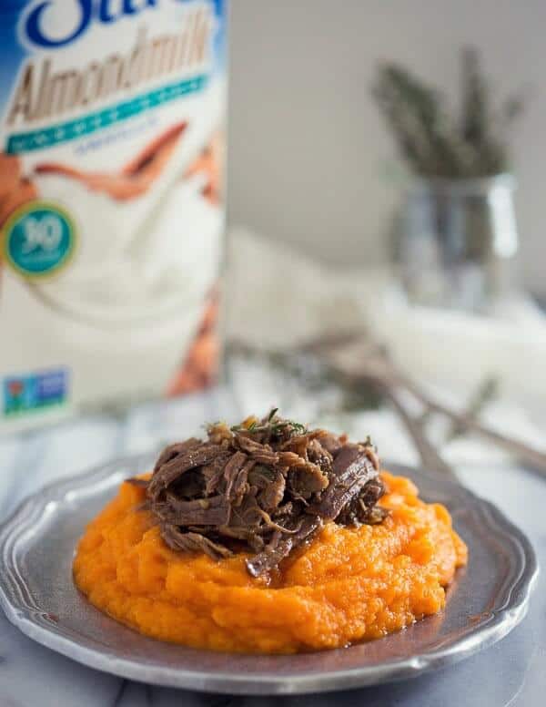 Parsnip puree topped with meat on a small silver plate.