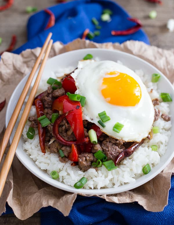 This spicy beef and red pepper rice bowl is cooked with dried red chili peppers and topped with a runny egg for a quick and easy dinner.