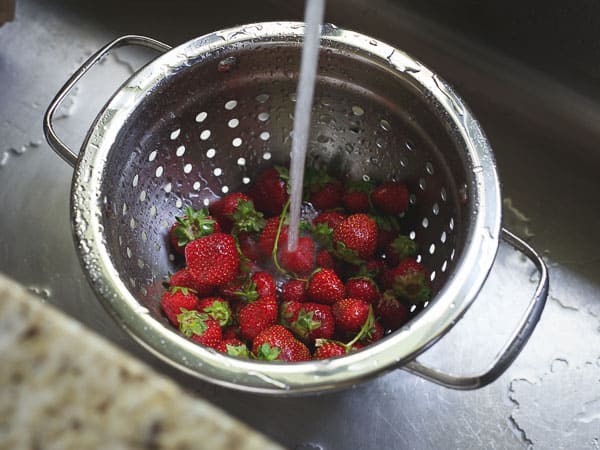 strawberries in colander for making a gluten-free, grain-free strawberry almond galette