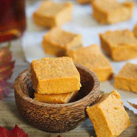 Pumpkin pie fudge squares stacked in a small wooden bowl.