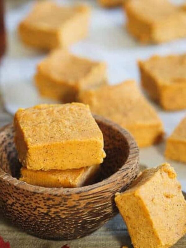 Pumpkin pie fudge squares stacked in a small wooden bowl.
