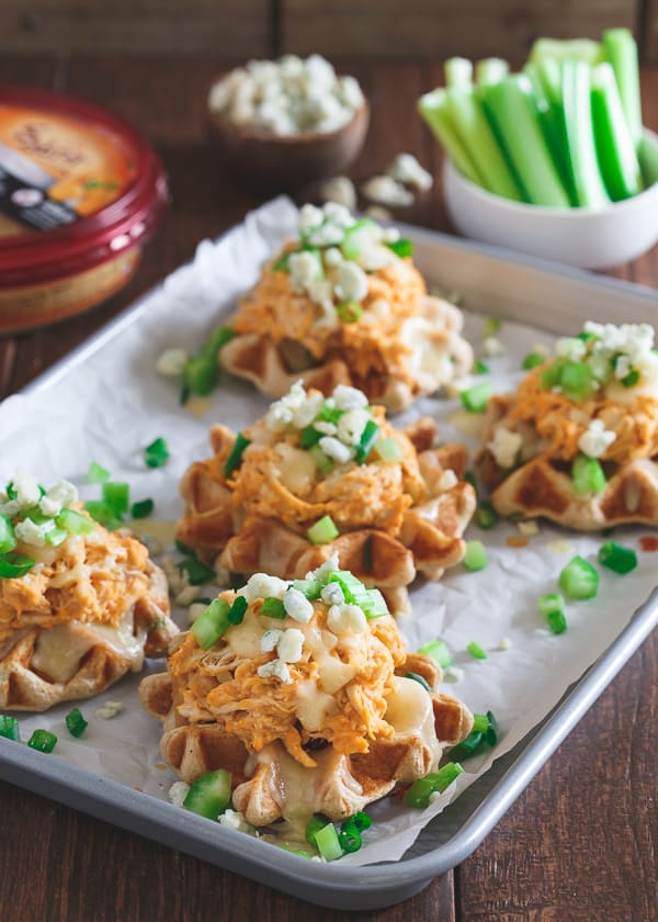 The perfect game day bite, these buffalo hummus chicken waffle bites have sharp melted cheddar, blue cheese crumbles and crunchy chopped celery on top!