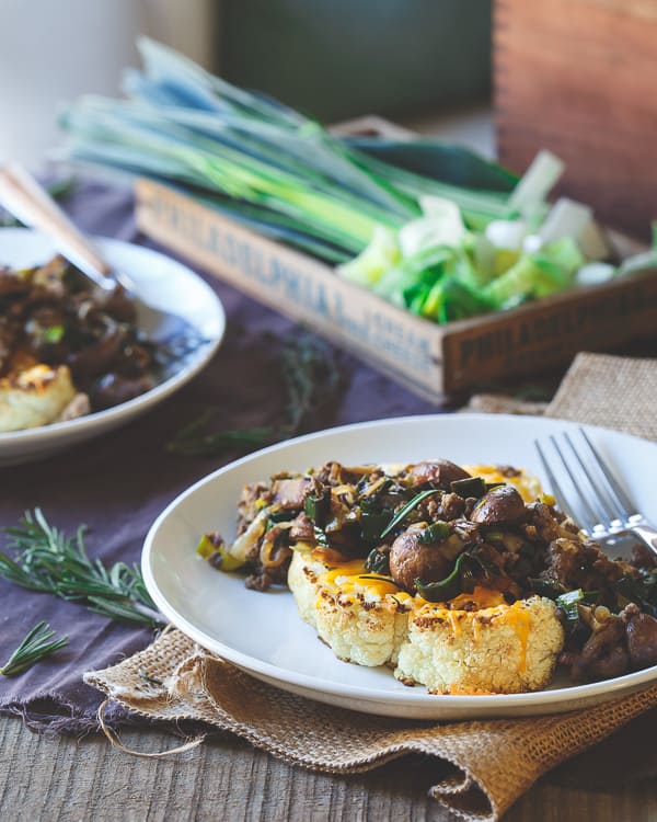 Thick cut and hearty cauliflower steaks are topped with melted cheddar and a savory bison, crimini mushroom and leek saute - total comfort food!