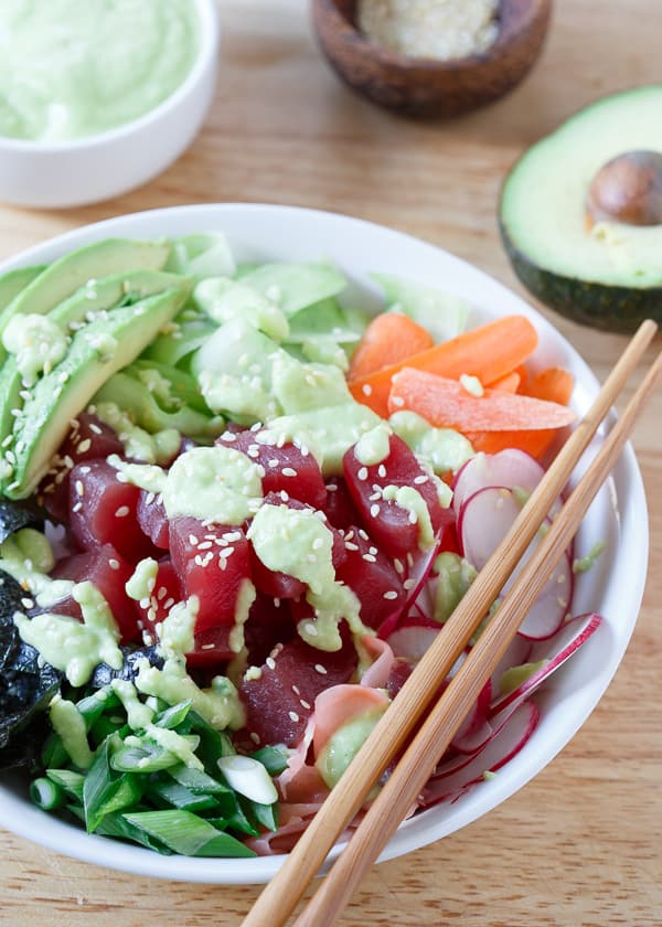 Get your sushi fix at home! This quick and easy tuna sushi bowl is packed with radishes, carrots, cucumber, seaweed and avocado then drizzled in a spicy avocado wasabi dressing. 