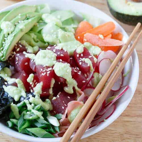 Get your sushi fix at home! This quick and easy tuna sushi bowl is packed with radishes, carrots, cucumber, seaweed and avocado then drizzled in a spicy avocado wasabi dressing.