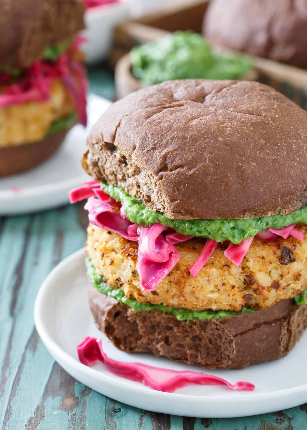 These vegetarian cauliflower burgers are stuffed with cheddar cheese and topped with pickled red cabbage and a zesty, refreshing cilantro pesto. 