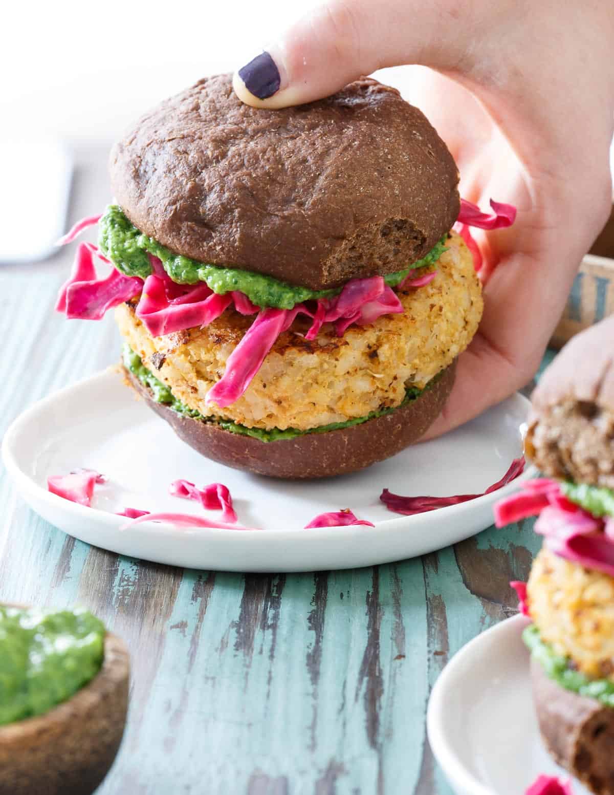 These Cheddar Cauliflower Burgers are a delicious spin on a vegetarian burger with pickled cabbage and a refreshing cilantro pesto.