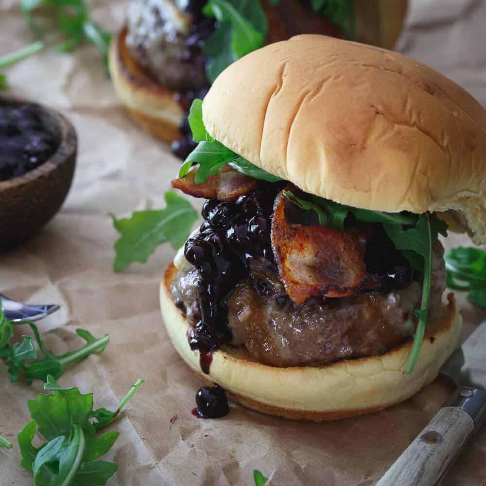 This brie burger is topped with a sweet and tangy blueberry BBQ sauce, crispy bacon and fresh arugula.