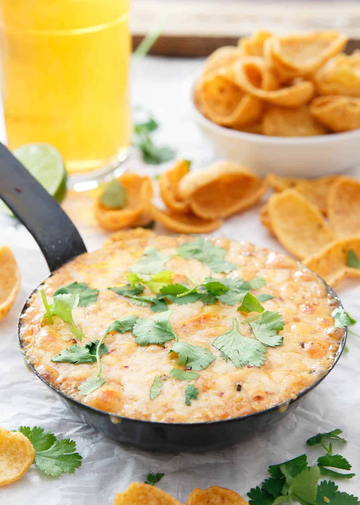 This hummus fundido has a spicy chipotle kick to it. Use chips or even roasted vegetables to dive into this baked cheesy dip.