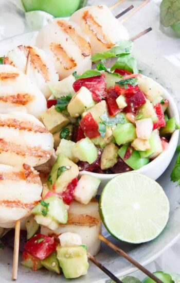 These grilled scallops are simply prepared and topped with a fresh summery tomatillo plum salsa for a delicious light meal.