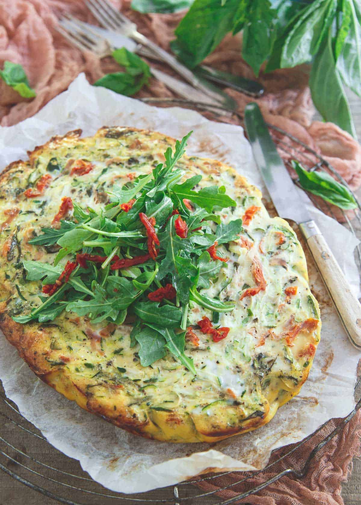 This slow cooker frittata is bursting with grated zucchini, sun dried tomatoes, basil and prosciutto then topped with a simple arugula salad. Great for a summer breakfast or dinner!