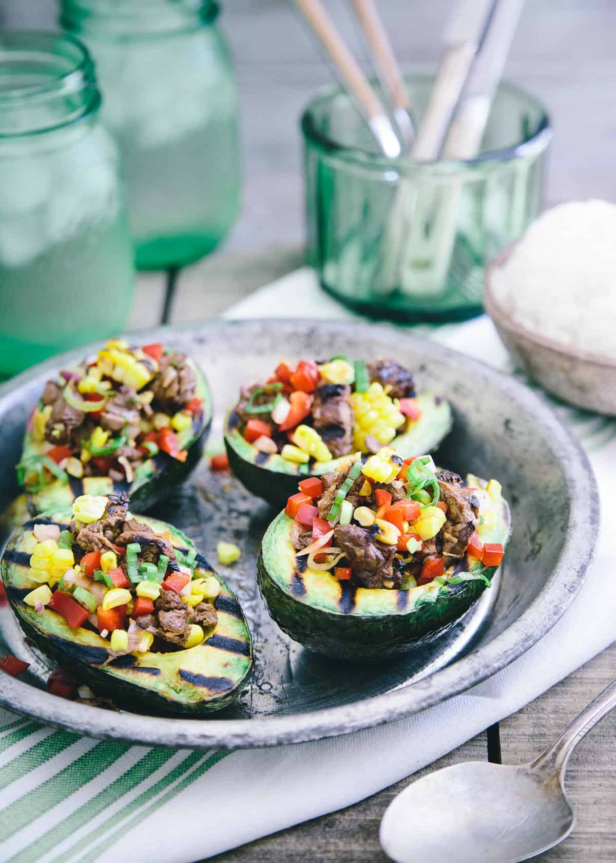 These grilled avocados are stuffed with Asian marinated steak, red peppers, grilled corn and scallions. Serve with a side of rice for a great summer meal!