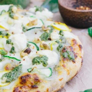 Zucchini pizza with white sauce and pesto.