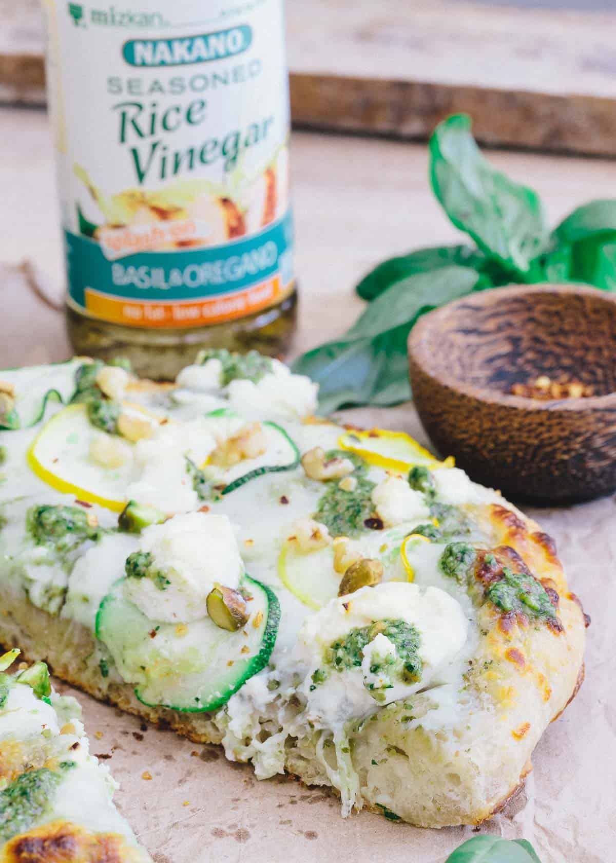 This skillet zucchini pesto pizza is made with Nakano basil and oregano rice vinegar for a tangy twist to traditional pesto.