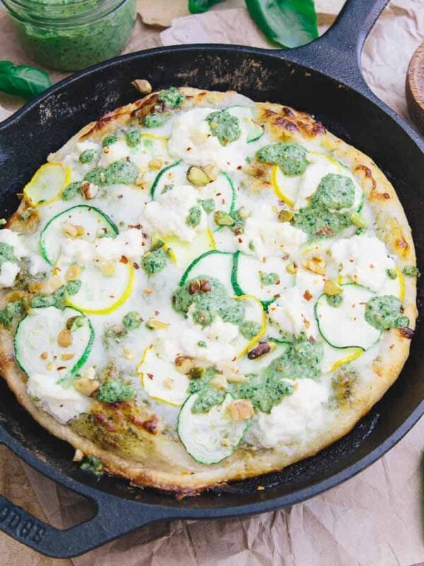 This skillet zucchini pesto pizza has a crispy yet chewy crust. With layers of tangy basil pesto, mozzarella, zucchini and ricotta it's perfect for summer!