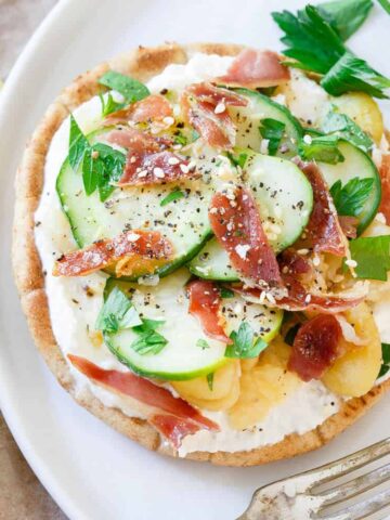 These fava bean grilled pita bites are layered with a base of creamy ricotta, tangy pickled cucumbers and crisp salty prosciutto. They make a sensational bite for a light lunch or appetizer!
