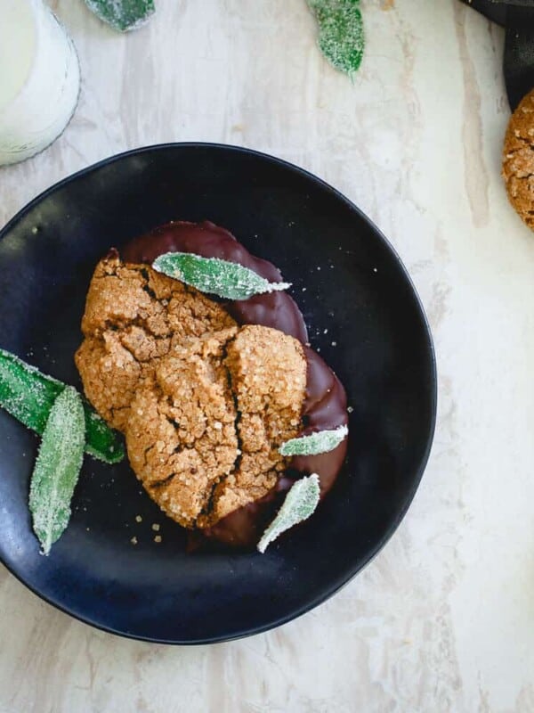 These flourless cashew almond butter cookies are dipped in dark chocolate and garnished with candied sage. They're a fun chewy winter treat!