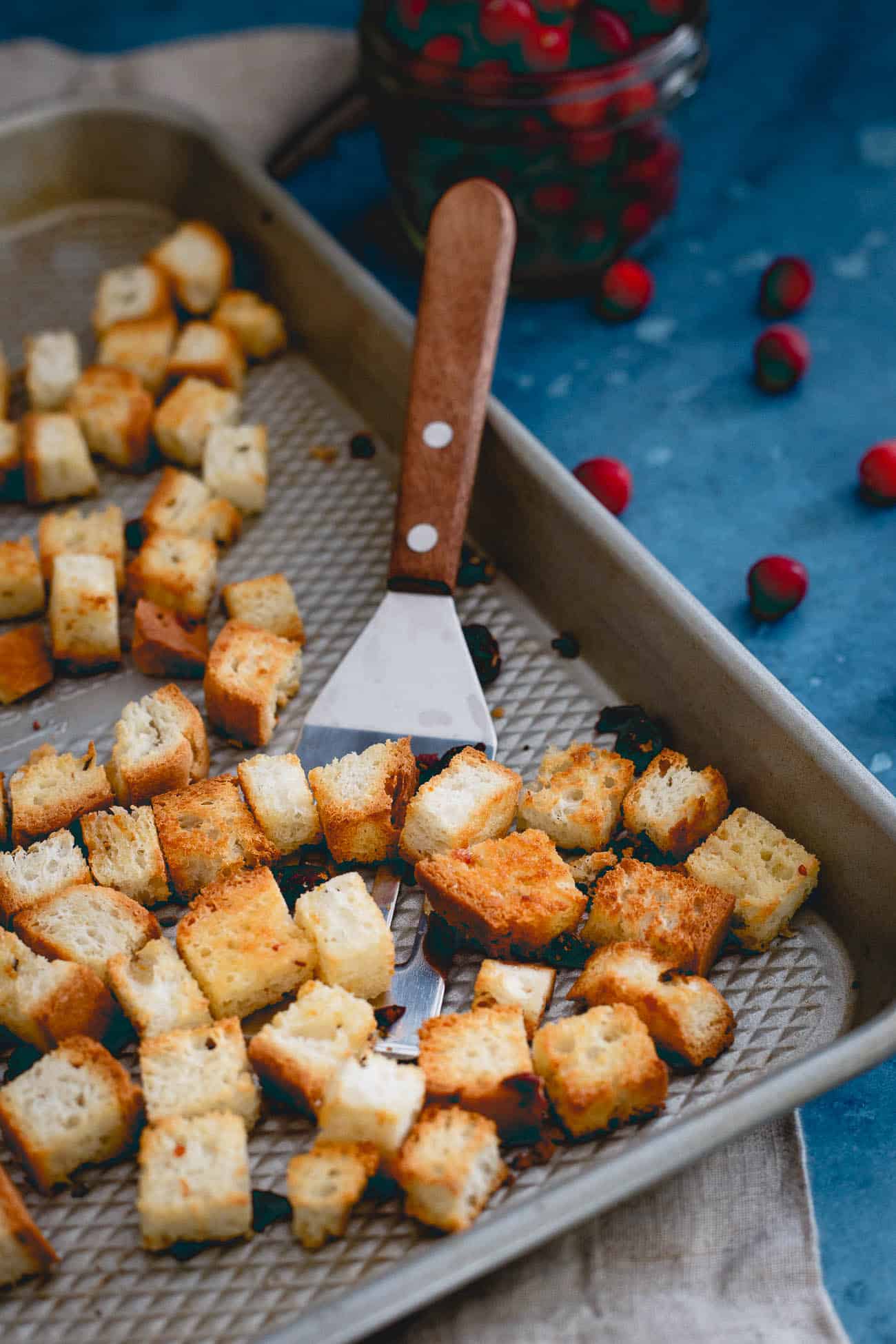 Homemade croutons on a pan with a spatula as a topping for broccoli salad.