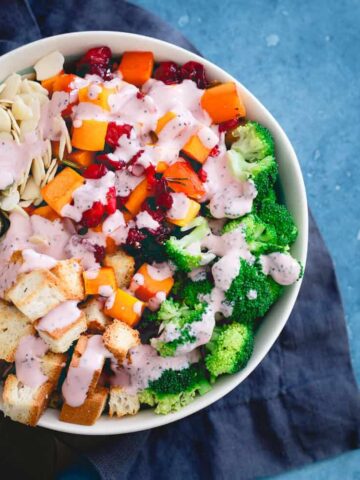 Maple syrup roasted cranberries and butternut squash are added to this fall inspired broccoli salad with toasted croutons, almonds and pepitas.