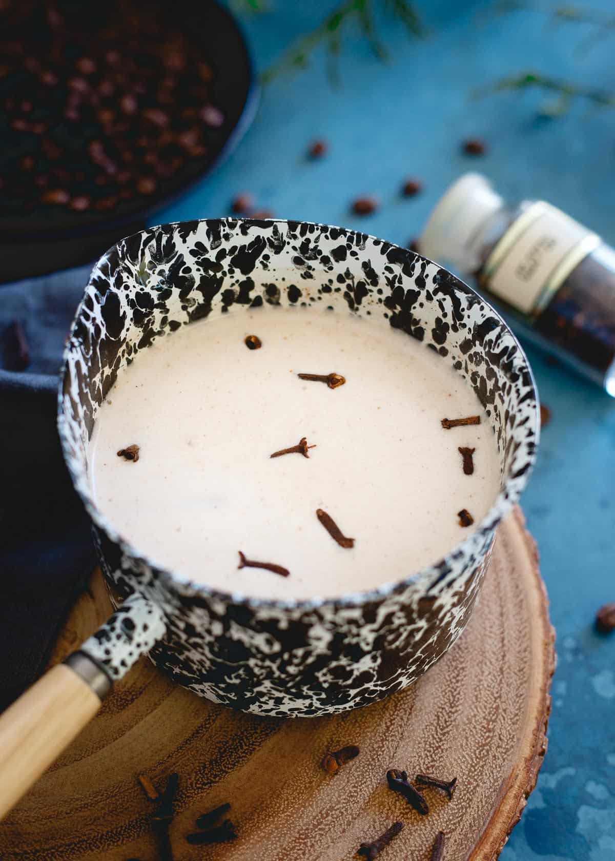 Spiced coconut milk makes the perfect cozy winter addition to some bourbon and coffee for this festive drink!