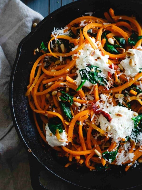 Butternut squash noodles in a cast iron skillet with spinach and ricotta.