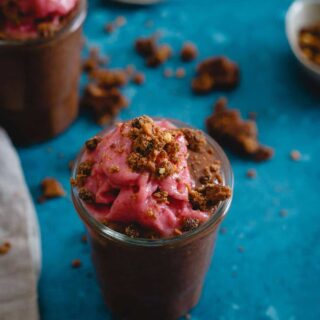 This peanut butter chocolate chia pudding is a healthy dessert parfait topped with whipped frozen strawberries and peanut butter chocolate chip LARABAR crumbles.