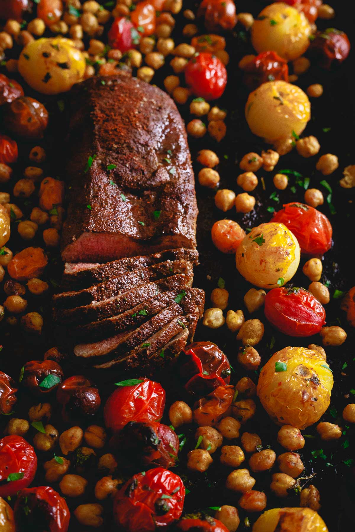 Get dinner on the table fast with this one pan roasted lamb dinner. Packed with flavorful spices, roasted tomatoes and chickpeas.