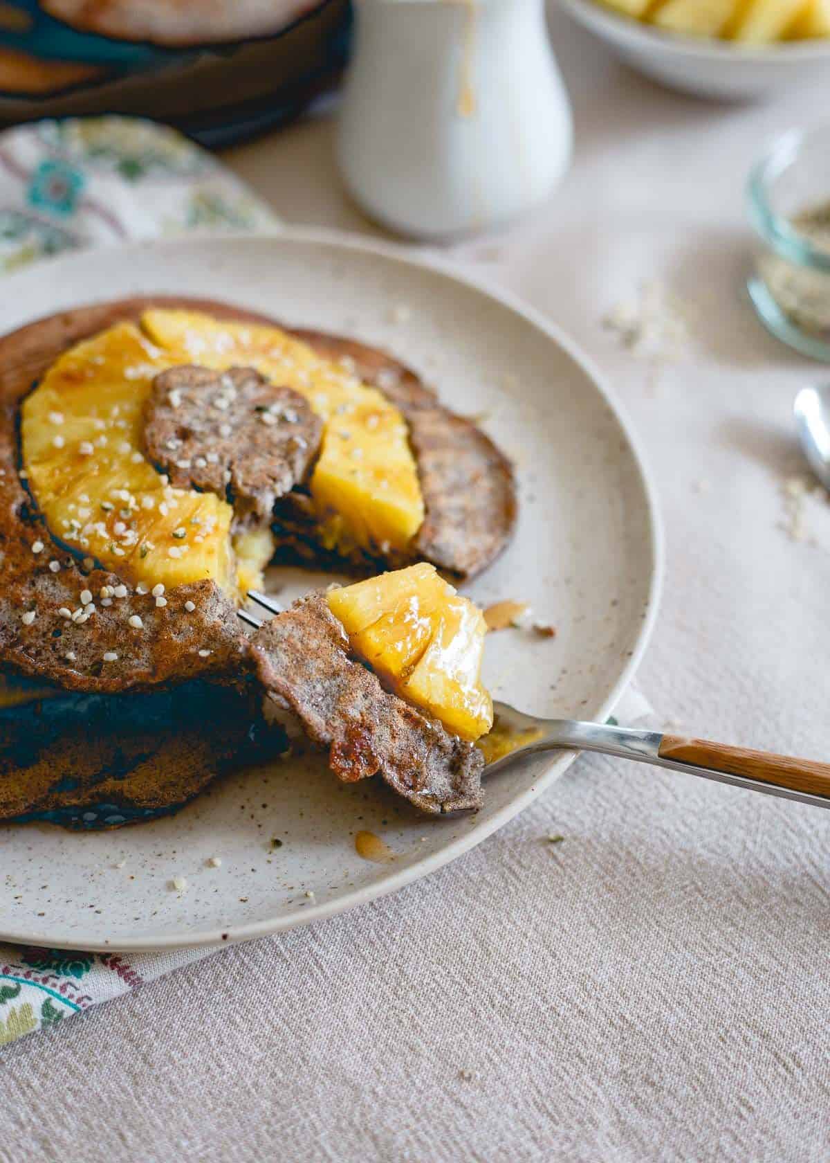 Pineapple buckwheat pancakes on a plate with a fork.